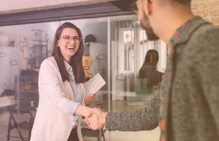 Two people shaking hands in business setting