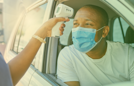 Patient has temperature taken while in a car driving through a lab.