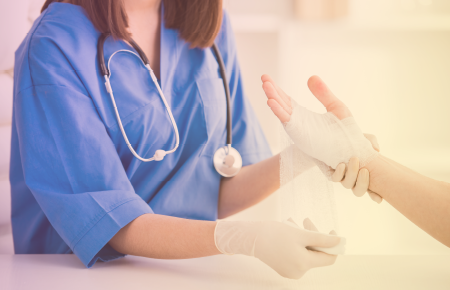 Nurse wrapping hand in guaze